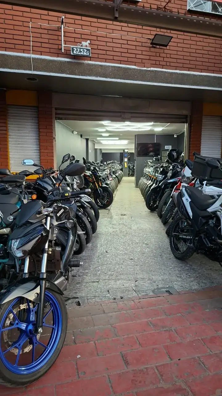Entrada de la sede Carrera 30, con motos exhibidas a ambos lados